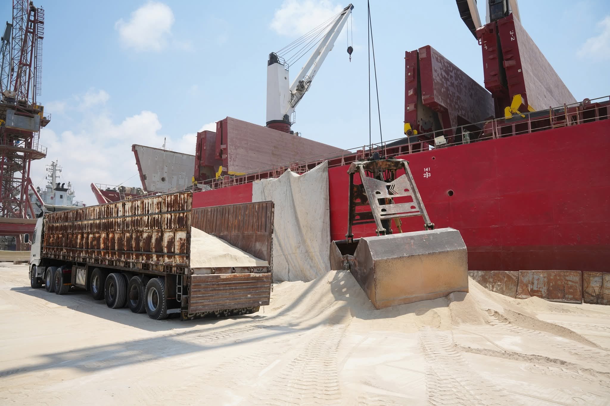 Wheel loader charging road trucks from the discharge heap